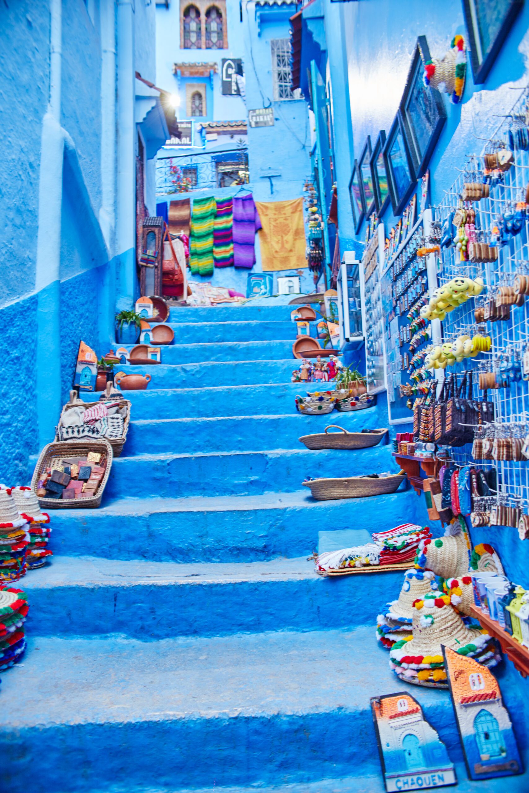 Many different Souvenirs and gifts in the streets of Chefchaouen. Paintings, carpets, clothing and handmade products on the streets of Morocco. Morocco, Chefchaouen 13 Dec 2017