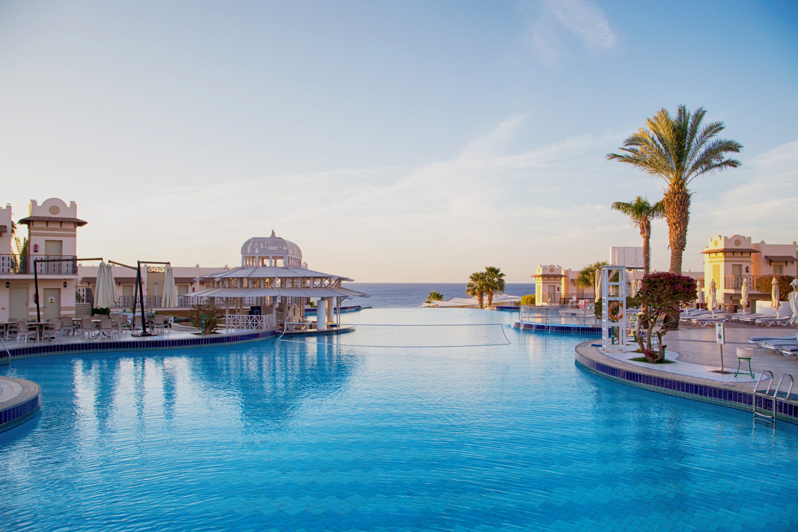 SHARM EL SHEIKH, EGYPT – March 18, 2019: Building, Concord Hotel. View of the beautiful pool with palm trees. Background for tourism and travel. Clear water and blue sky.