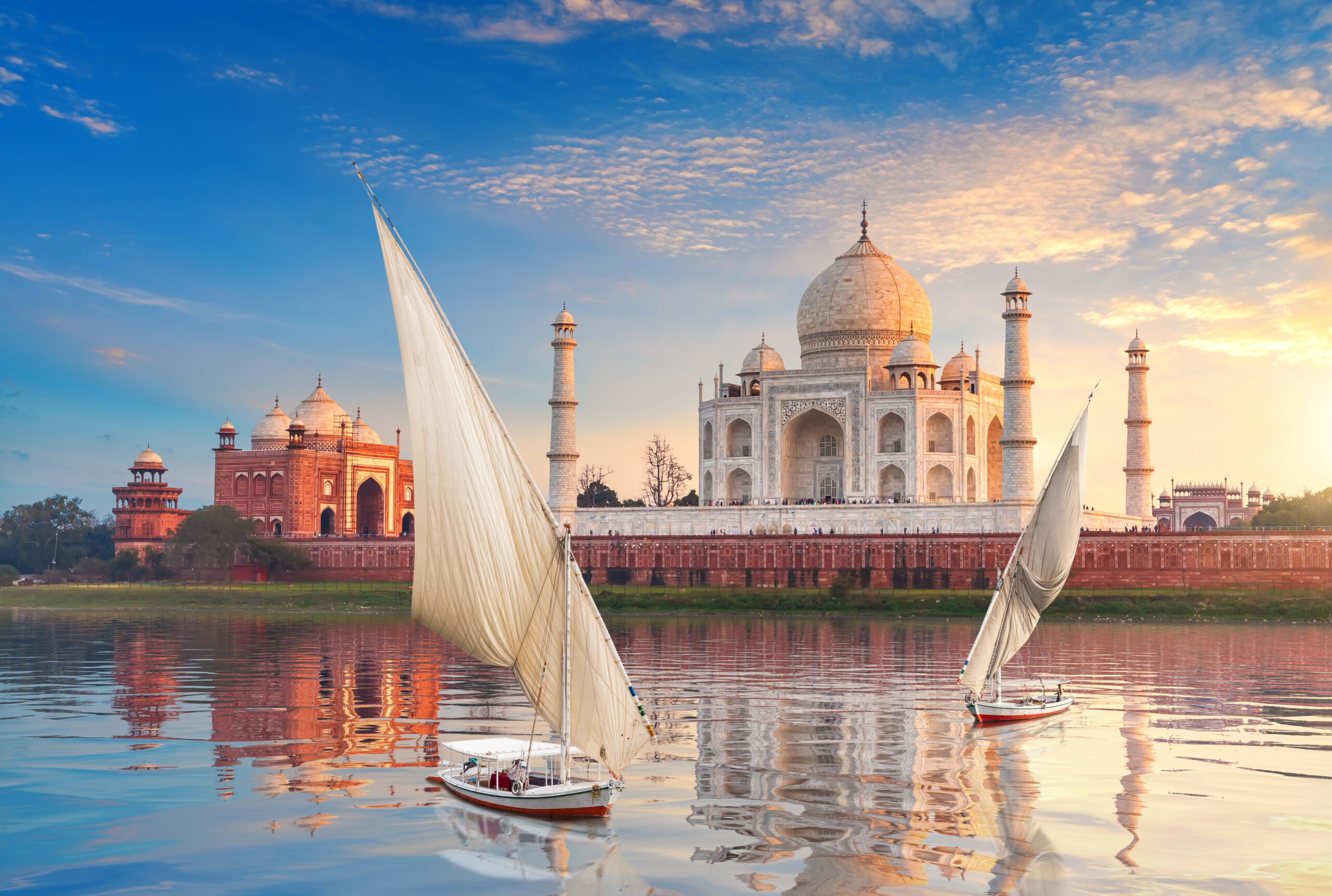 Famous Taj Mahal complex, the Yamuna river and boats, beautiful sunset, Agra, India