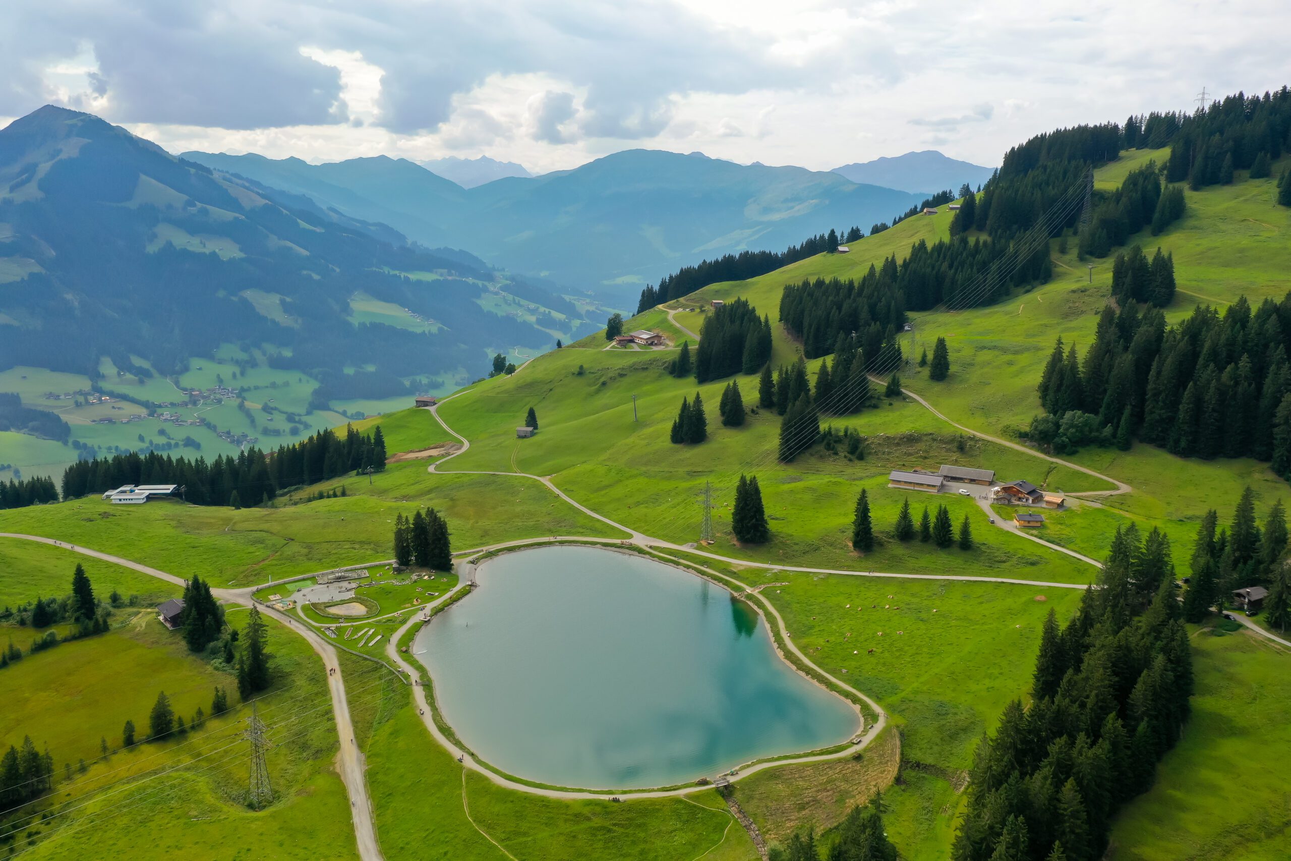 Landscape of the Filzalmsee surrounded by hills covered in greenery in Austria