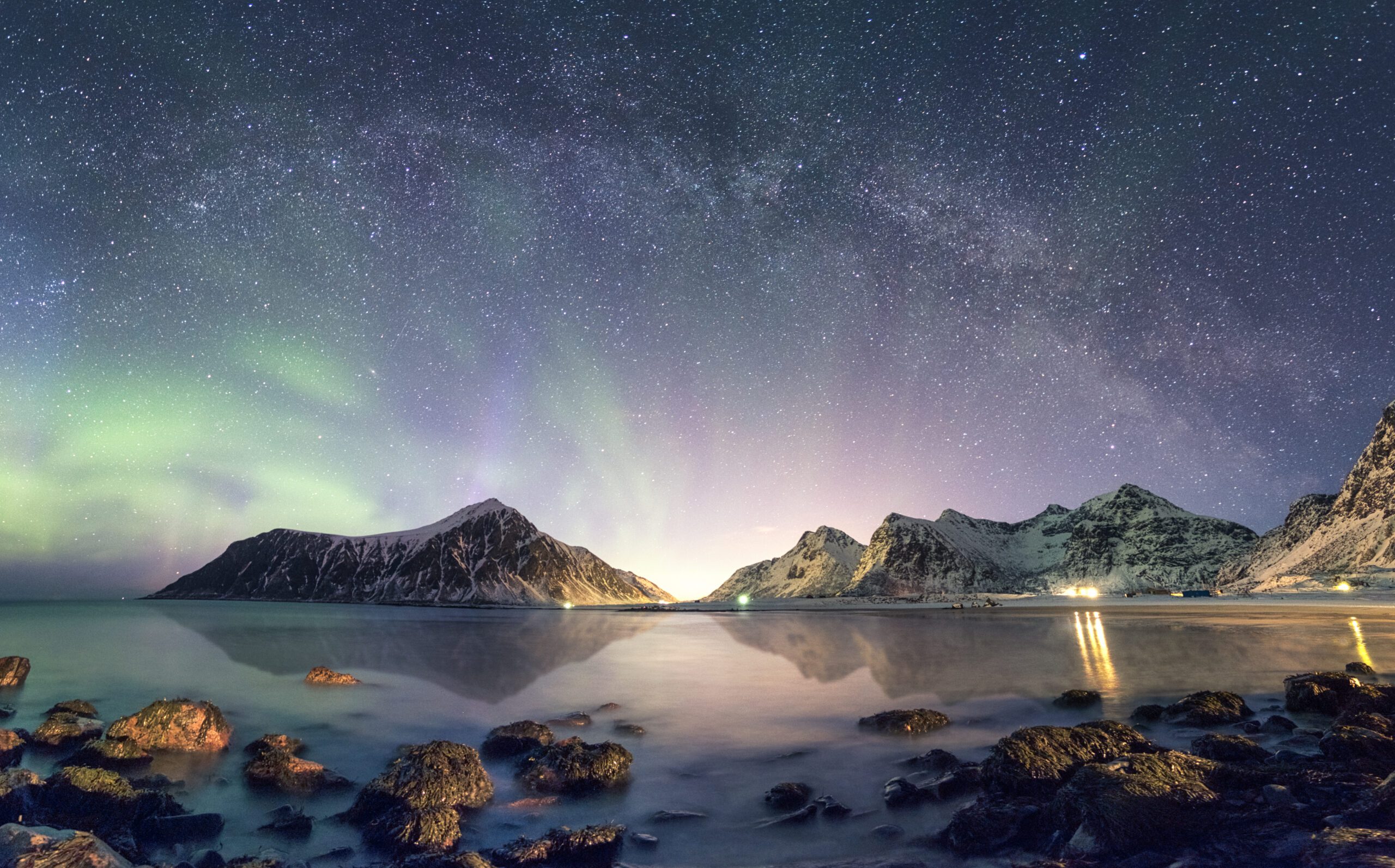 Panorama of Aurora borealis with Milky way galaxy over snow moun