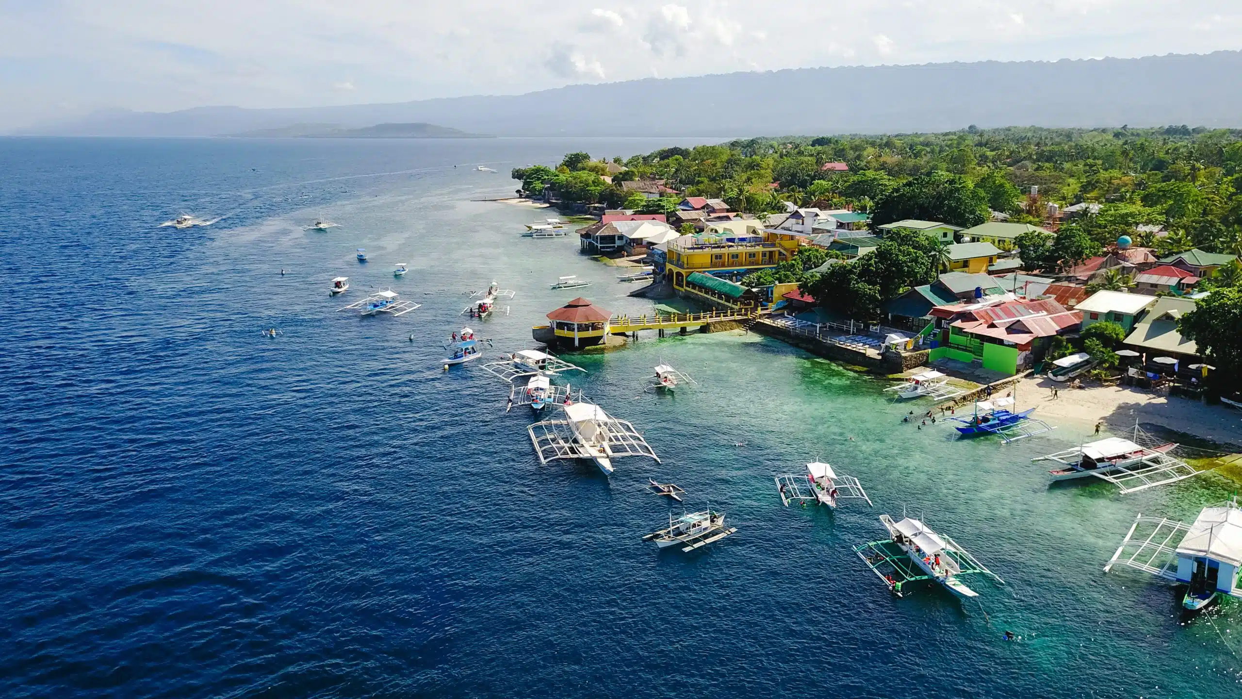 Aerial view of sandy beach with tourists swimming in beautiful c