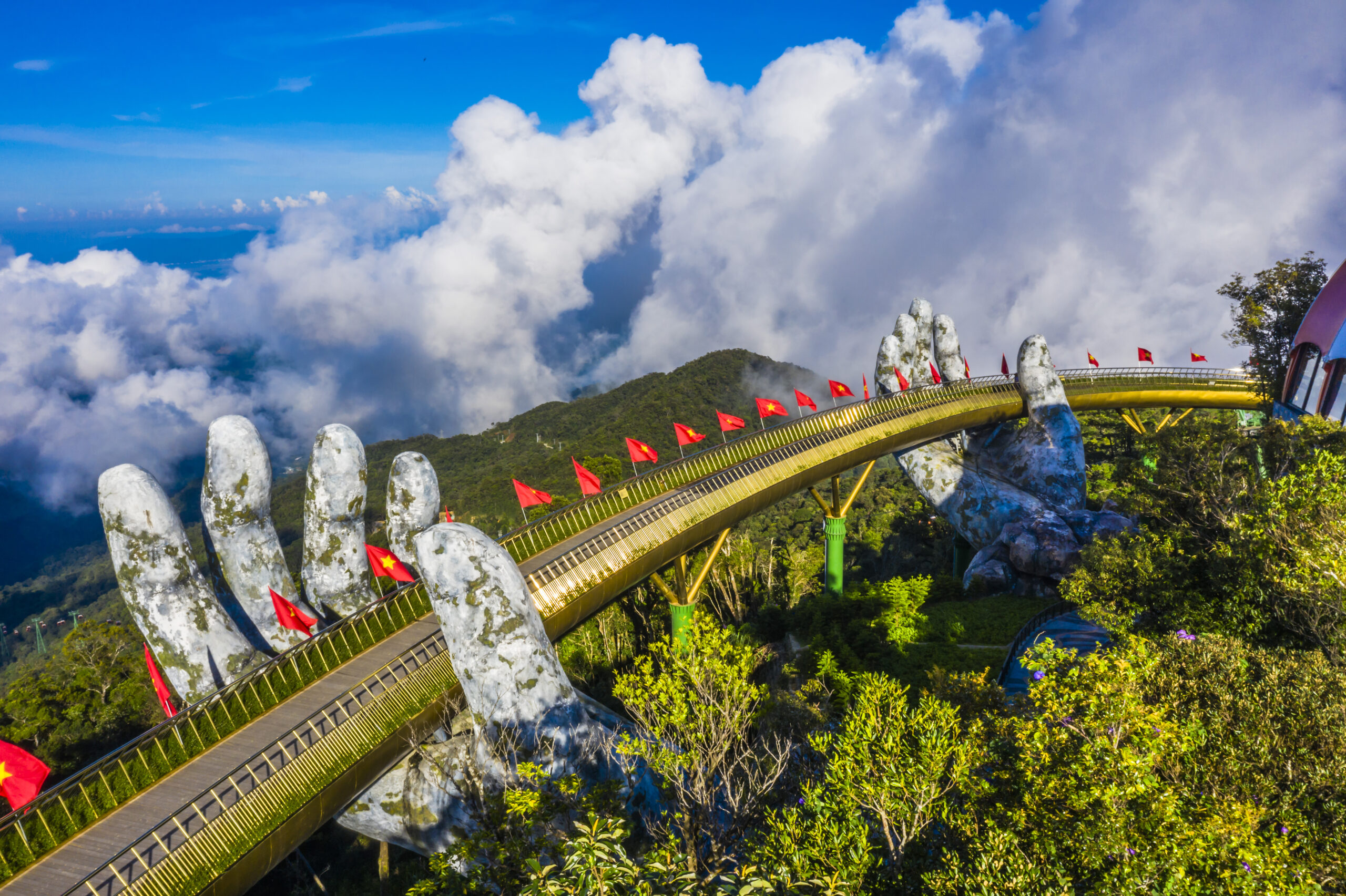 aerial view golden bridge is lifted by two giant hands two rows vietnamese flags ba na hill danang vietnam travel landscape concept scaled